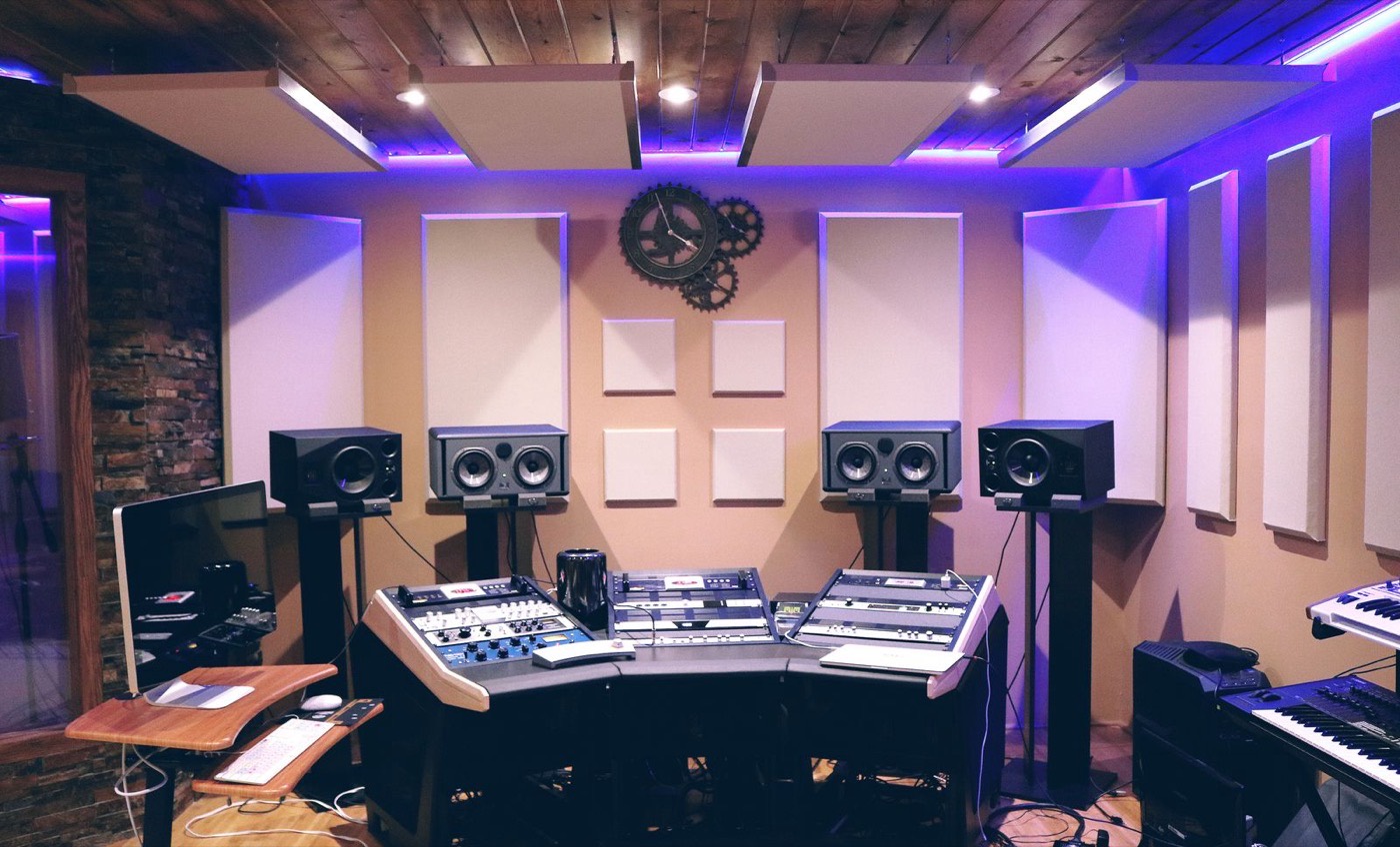 A small project studio with monitors, acoustic panels and a control desk