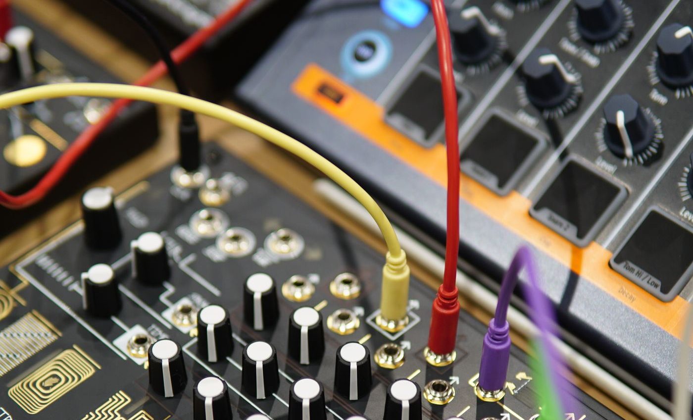 Coloured patch cables plugged into the front of a synthesiser rack